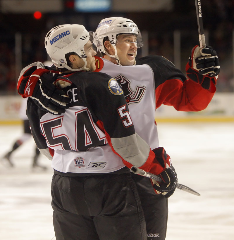 Jacob Lagace, left, celebrates with Travis Turnbull after scoring a second-period goal Sunday against the Springfield Falcons. The Pirates lost 2-1 in overtime, a day after clinching the Atlantic Division title.