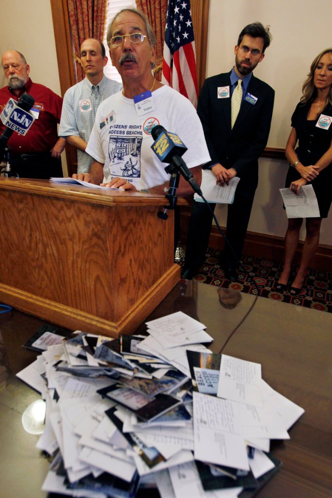 Ralph Coscia of Point Pleasant Beach, N.J., stands near a pile of “Dear Gov. Christie” postcards from opponents of New Jersey’s proposed beach access rules, on Wednesday in Trenton.