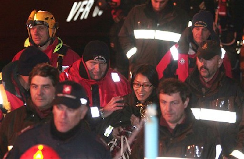 A passenger from South Korea, center, walks with Italian Firefighters after being rescued from the luxury cruise ship Costa Concordia which ran aground the tiny Tuscan island of Giglio, Italy, Sunday, Jan. 15, 2012. The luxury cruise ship ran aground off the coast of Tuscany, sending water pouring in through a 160-foot (50-meter) gash in the hull and forcing the evacuation of some 4,200 people from the listing vessel early Saturday, the Italian coast guard said. (AP Photo/Gregorio Borgia)