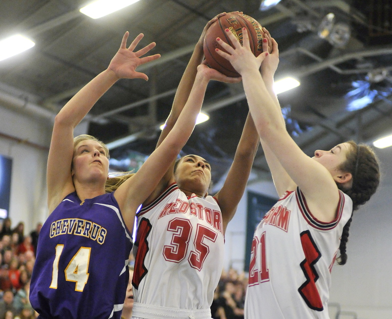 Brooke Flaherty, left, of Cheverus battles for a rebound against Scarborough's Carly Rogers, center, and Courtney Alofs during their Western Class A girls' basketball quarterfinal at the Portland Expo. Third-seeded Scarborough made a late charge to pull out a 39-35 win.