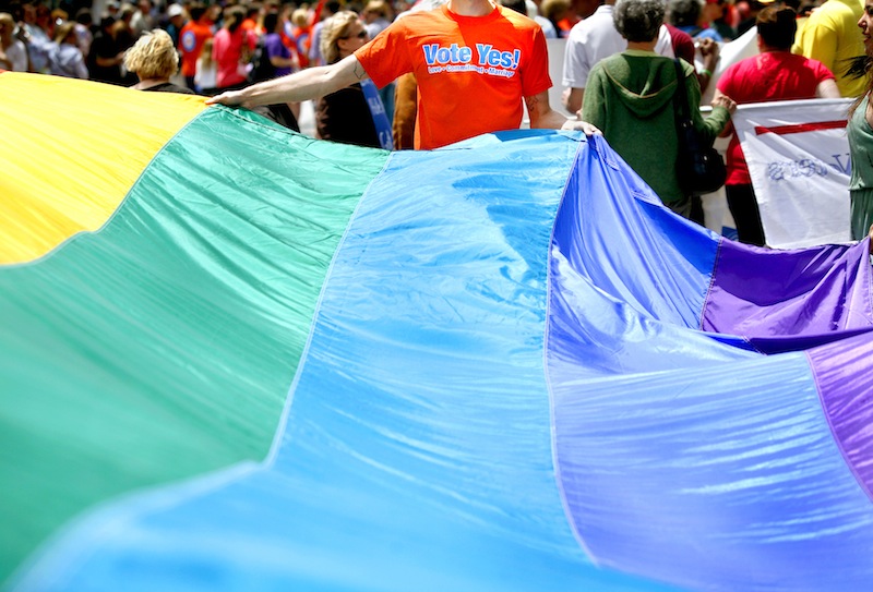 Chris Sawyer of South Portland with Mainers United for Marriage helps carry the rainbow flag during the Southern Maine Pride Parade and Festival on Congress Street in Portland on Saturday, June 16, 2012.