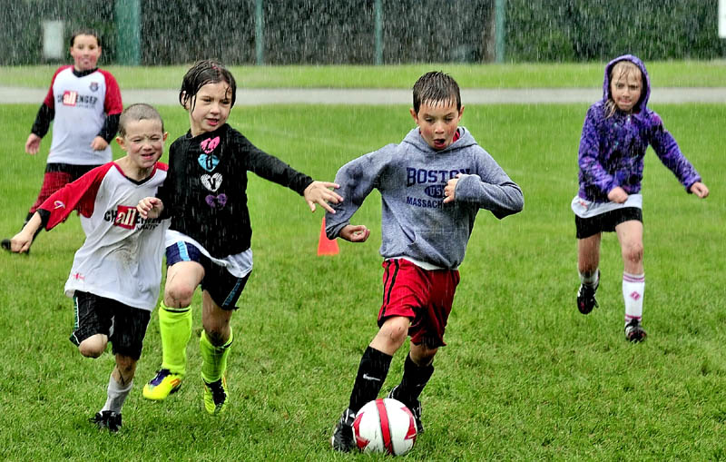 kids playing soccer in the rain