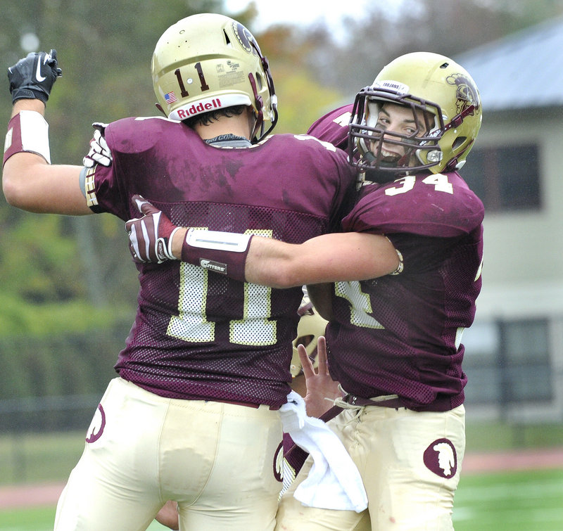 Nick Kenney of Thornton Academy, right, and quarterback Eric Christensen celebrate Saturday after Kenney scored a touchdown that helped the Trojans remain unbeaten by defeating Scarborough, 35-7.