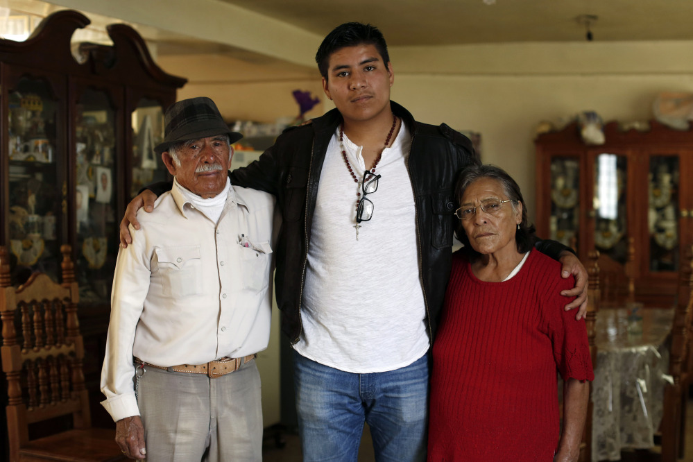In this Friday, Oct. 3, 2014 photo, Dario Guerrero, center, poses for a portrait with his grandparents Dario Guerrero Garrido and Crescencia Garcia Vazquez at their home in the outskirts of Mexico City.