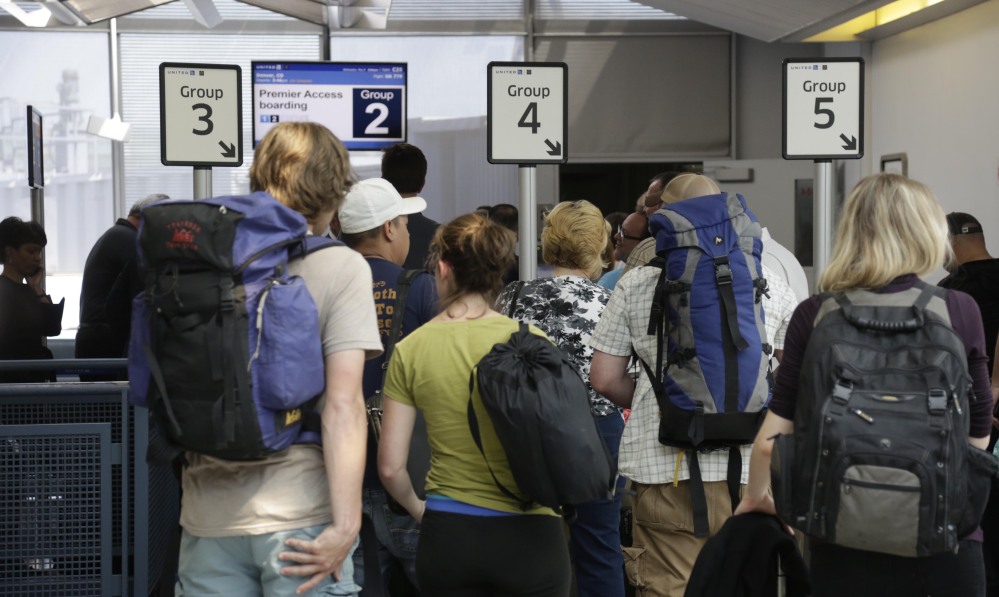 Passengers wait at a United Airlines gate to board a flight at O’Hare International Airport in Chicago. Planes are filled with more passengers than ever before and there is less legroom.