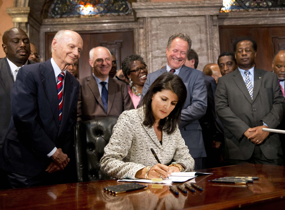 South Carolina Gov. Nikki Haley signs the bill Thursday to authorize the removal of the Confederate flag from the Statehouse grounds, more than 50 years after the rebel banner was raised to protest the civil rights movement.