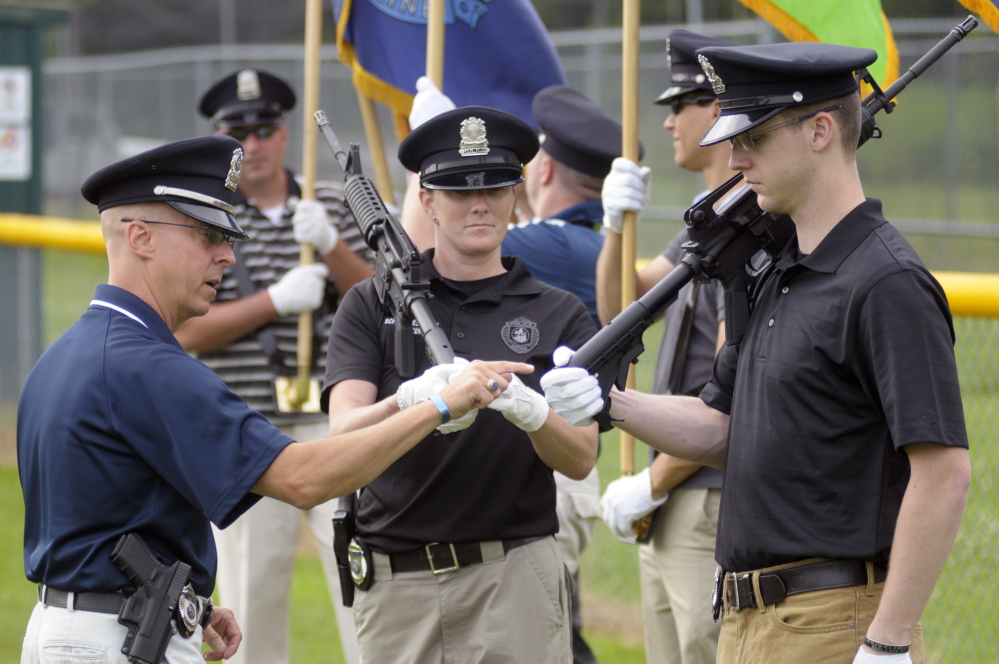 Augusta police Sgt. Christian Behr, left, and officers Carly Wiggin and Zachary Tobias discuss how to grip rifles during rehearsal on Thursday at Rivelli Little League Field in Augusta. The Augusta Police Honor Guard will be presenting the colors Friday for the Red Sox game at Fenway Park.