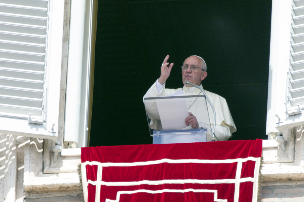 Pope Francis delivers his blessing to faithful during the Angelus noon prayer from his studio window overlooking St. Peter’s Square at the Vatican on Sunday.