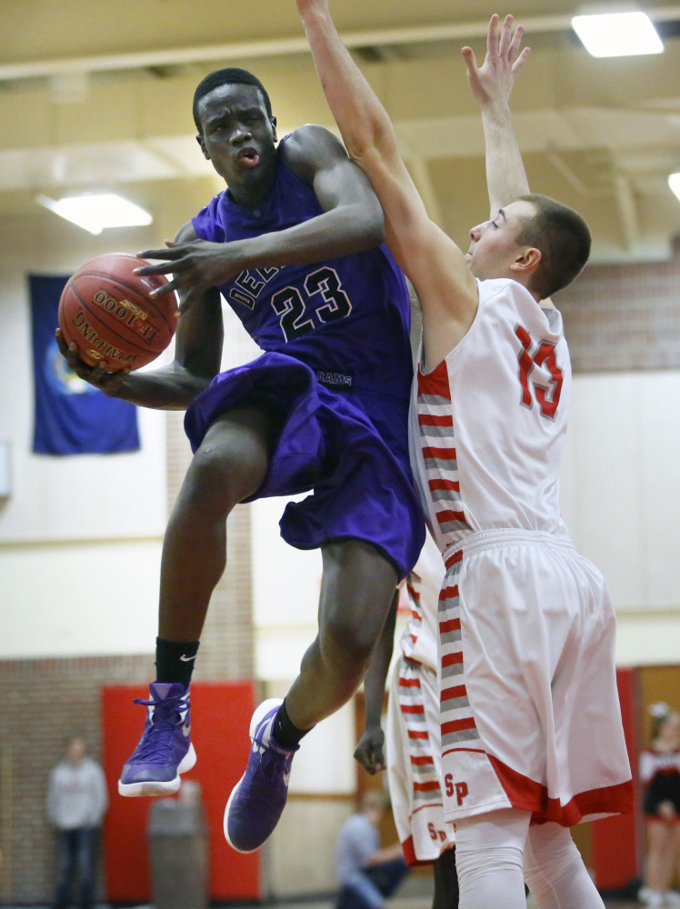 Anthony Lobor of Deering drives to the basket against Jack Fiorini of South Portland during a Class AA basketball game Friday night in South Portland. Lobor had 12 points and 13 rebounds in a 66-46 win.
