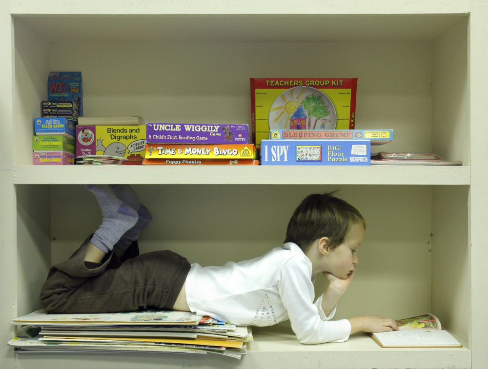 Eliza Crowley stretches out on a storage shelf during reading time at Cliff Island School in 2009. "Yes, Virginia, children still read books, turn pages and are absorbed in the process," says a reader who was happy to see this photo on the front page April 13.