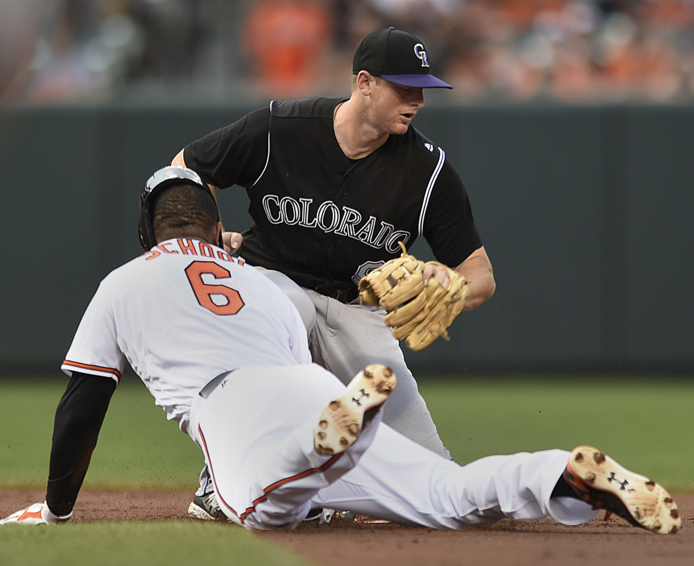 Baltimore's Jonathan Schoop slides into second as Colorado's Trevor Story takes the throw in the Orioles' 3-2 win Monday.