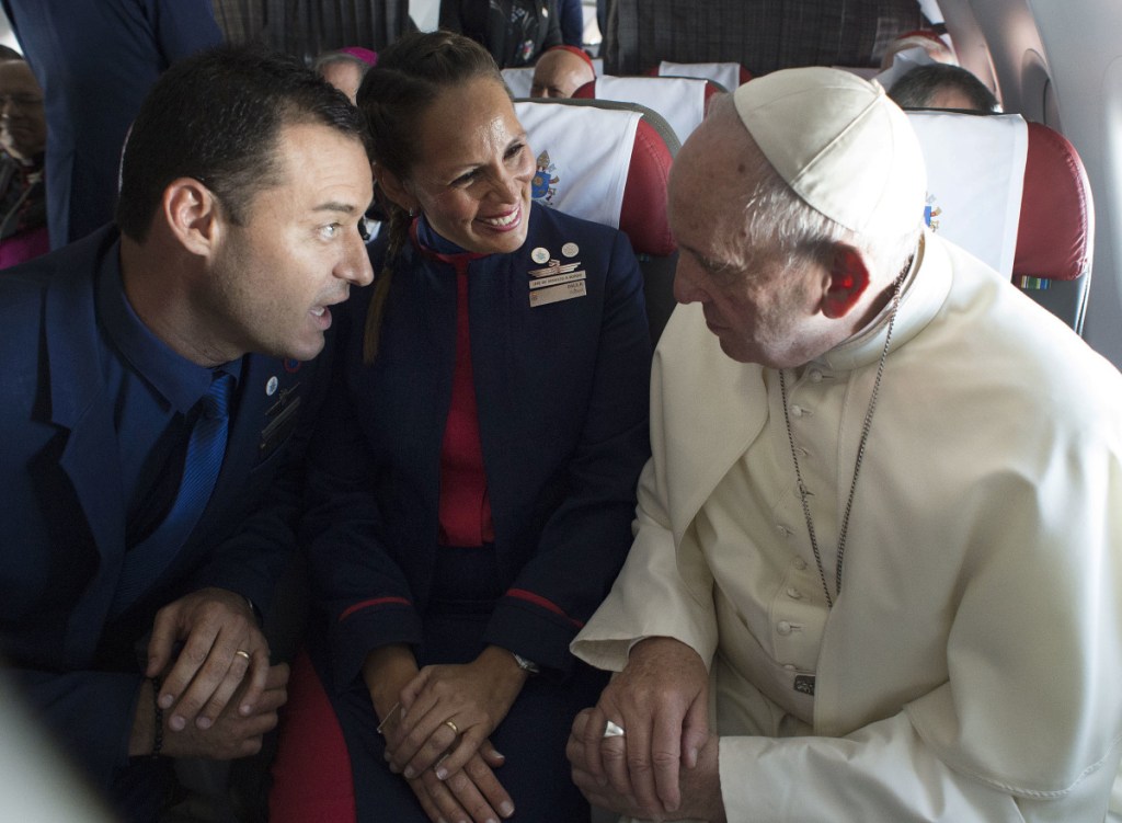 Pope Francis marries flight attendants Carlos Ciuffardi, left, and Paula Podest, center, during a flight from Santiago, Chile, to Iquique, Chile, on Thursday. Francis celebrated the first-ever airborne papal wedding, marrying the two flight attendants from Chile's flagship airline during the flight. The couple had been married civilly in 2010; however, they said they couldn't follow up with a church ceremony because of the 2010 earthquake that hit Chile.