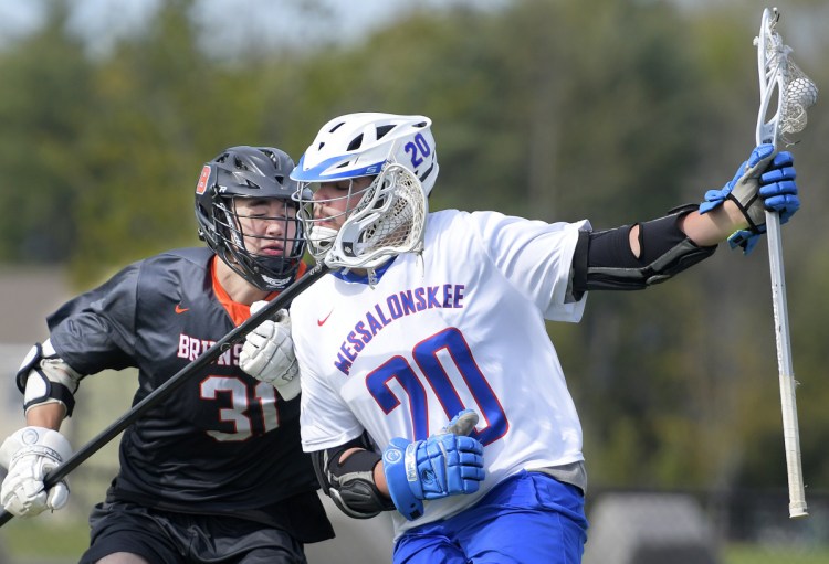 Messalonskee's Colin Kinney gets clipped by Brunswick's Sam Dorval in Wednesday's game at Waterville. Kinney scored three goals in Messalonskee's 12-11 loss.