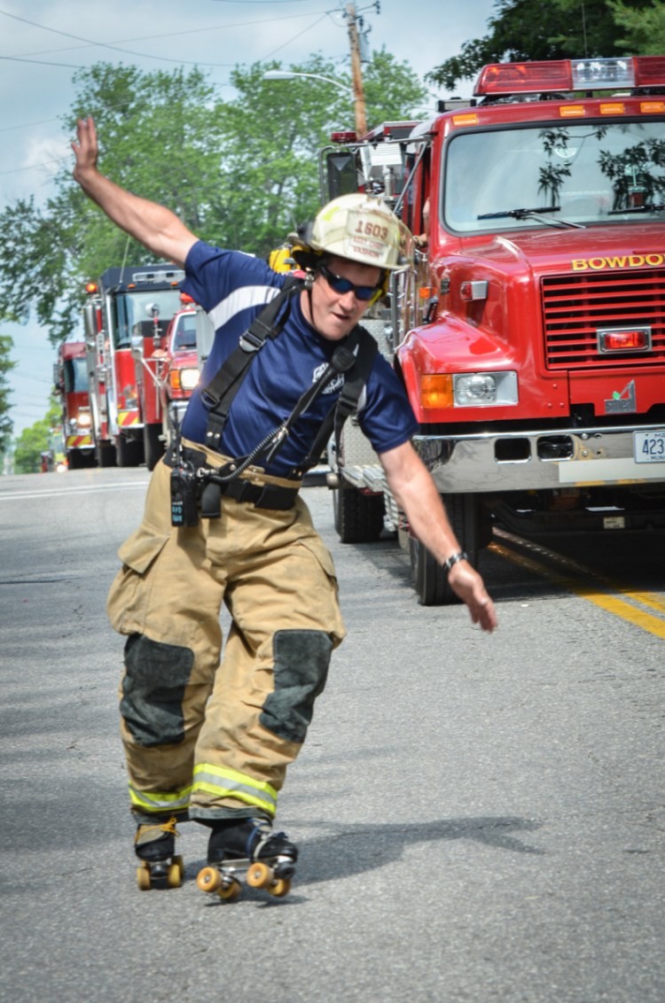 Richmond Assistant Fire Chief Michael Vashon roller skates along side a line of firetrucks while participating in the Richmond Days parade on Saturday.