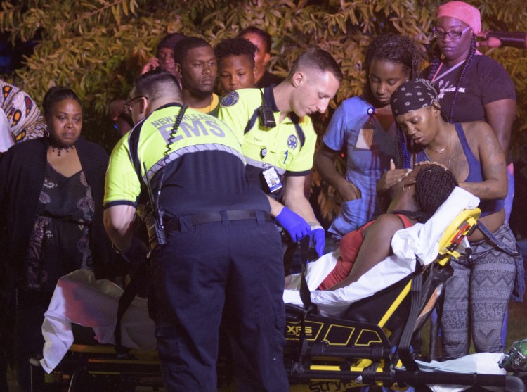 Emergency workers tend to a person who fainted near the scene of a shooting in New Orleans on Saturday night.