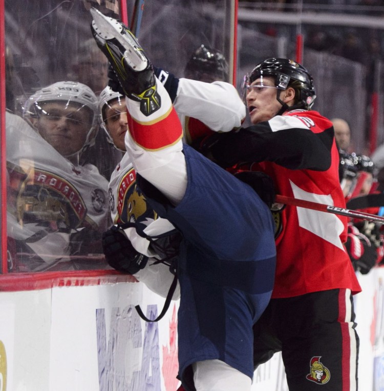 Thomas Chabot of the Ottawa Senators slams Nick Bjugstad of the Florida Panthers into the boards during the first period of Florida's 7-5 victory Monday.