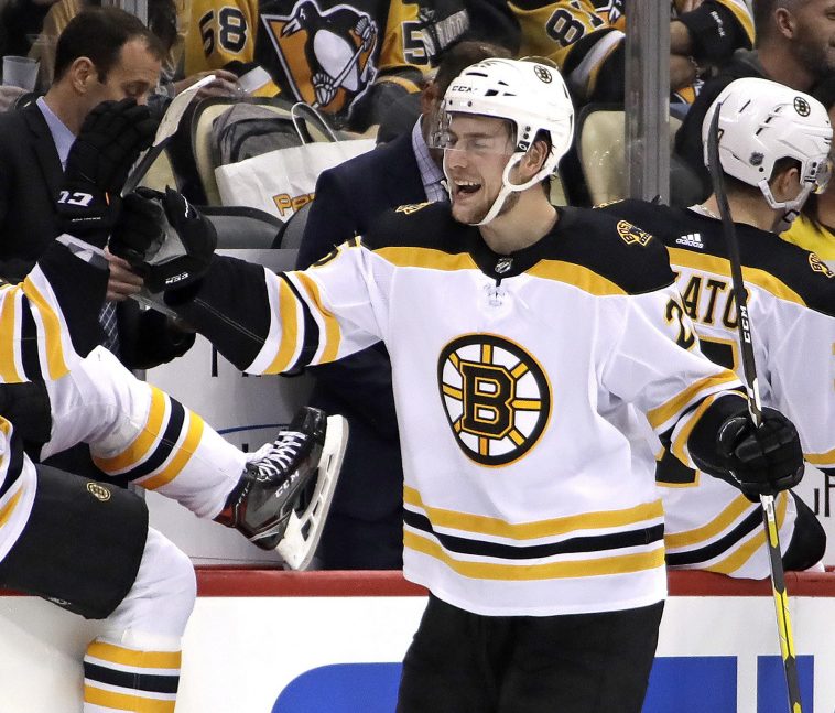 Boston Bruins defenseman Brandon Carlo, right, celebrates as he returns to the bench after scoring during the second period of a loss to the Penguins in Pittsburgh on Dec. 14. It was Carlo's first goal in 116 games.