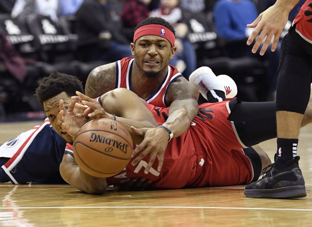 Bradley Beal of the Washington Wizards, top, competes for the ball with Kyle Lowry of the Toronto Raptors during the second half of Toronto's double-overtime win Sunday.