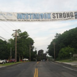 A banner displaying the Westbrook Strong 5K and information is stretched across and above a road